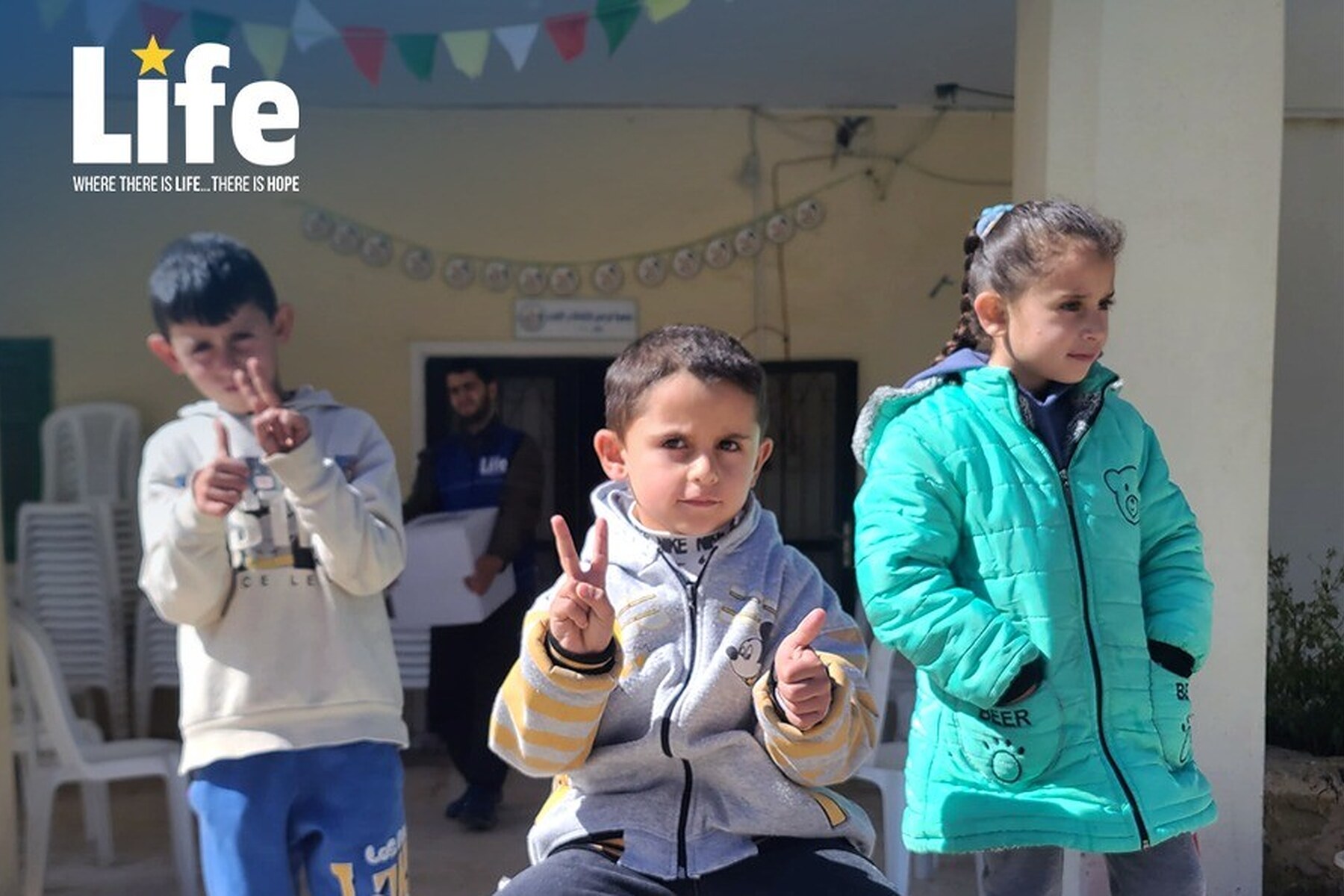 Menina libanesa diante de caixas de cestas alimentares do Ramadã 2026 distribuídas pela Life no sul do Líbano